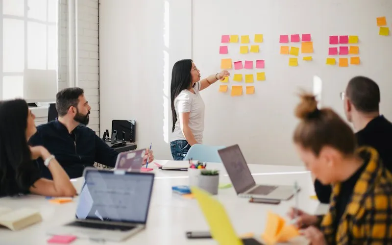 A team planning a software project around a board of sticky notes